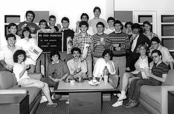 The 1987 Thresher staff demonstrate their obedience to posted instructions in the new Student Center lounges. Editor Lisa Gray ’88 is seated in the front row, behind a bottle of contraband soda. 