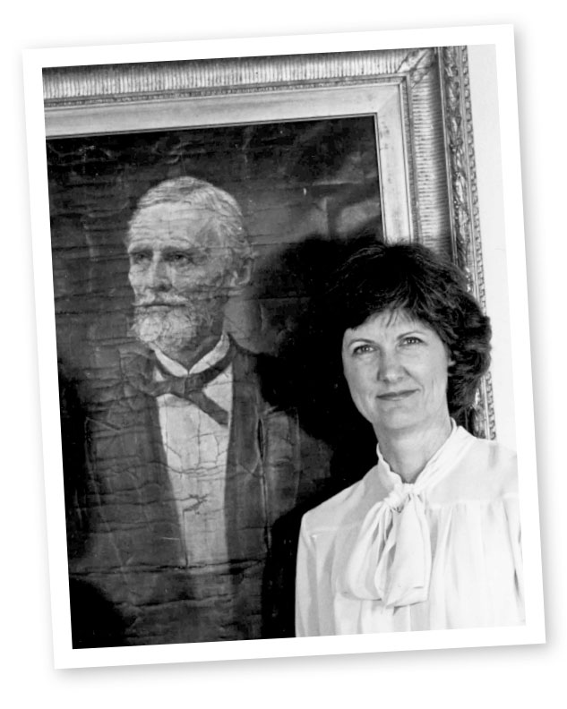 Lynda Crist poses with a painting of Jefferson Davis.